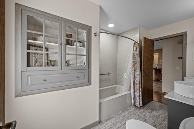 full bathroom featuring vanity, toilet, wood finished floors, and shower / tub combo with curtain