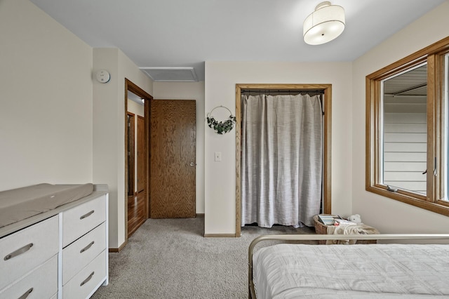 bedroom featuring baseboards, light carpet, and attic access