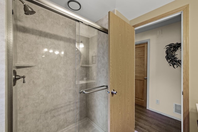 bathroom featuring visible vents, wood finished floors, and a stall shower
