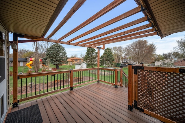 deck with a yard, a pergola, an outdoor structure, and a storage unit