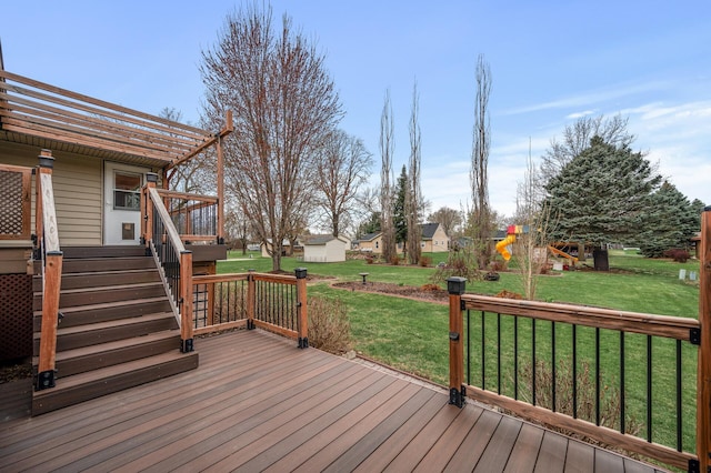 wooden terrace with a playground, an outbuilding, and a lawn