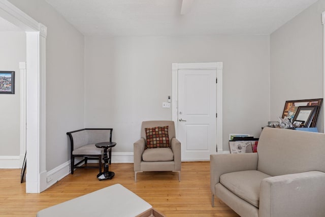 sitting room with baseboards and light wood finished floors