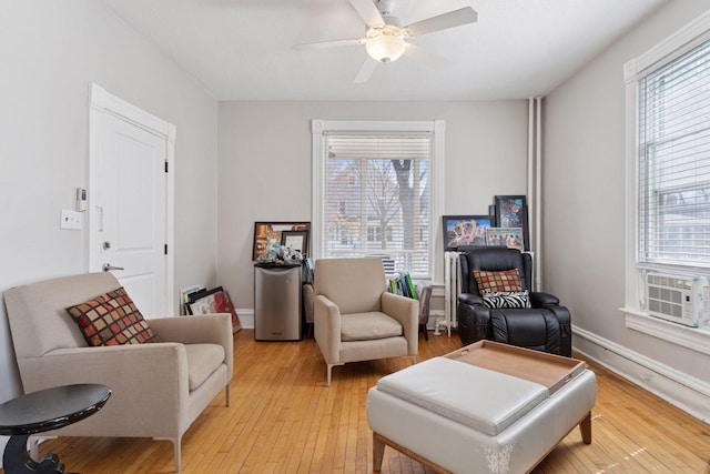 sitting room with ceiling fan, plenty of natural light, light wood-style flooring, and cooling unit