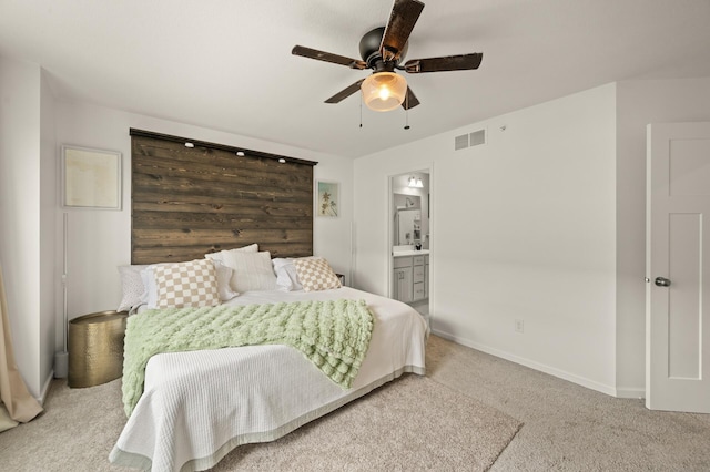 carpeted bedroom with visible vents, baseboards, a ceiling fan, and ensuite bathroom