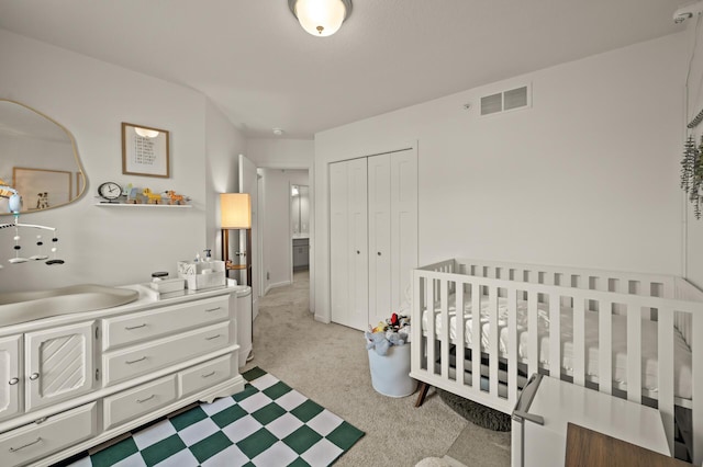 carpeted bedroom featuring visible vents and a closet