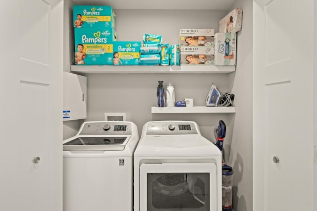 clothes washing area with washing machine and clothes dryer and laundry area