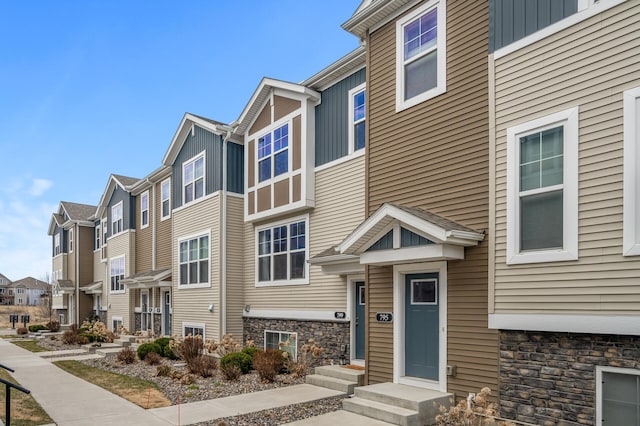 exterior space with board and batten siding, stone siding, and a residential view
