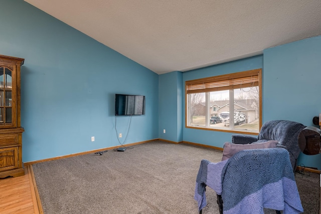 living area with light colored carpet, baseboards, and lofted ceiling