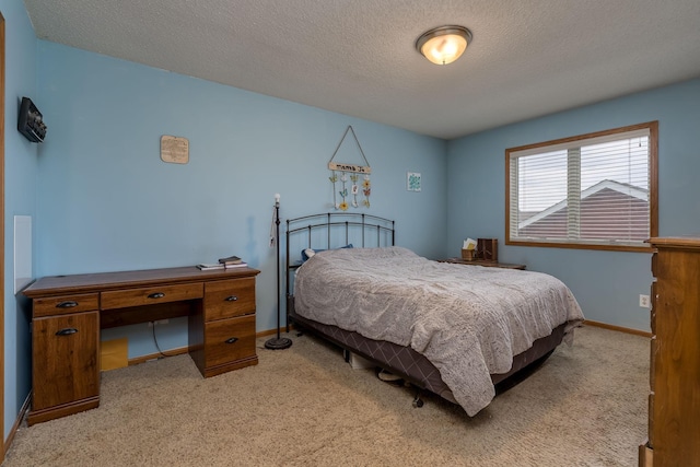 bedroom with light carpet, baseboards, and a textured ceiling