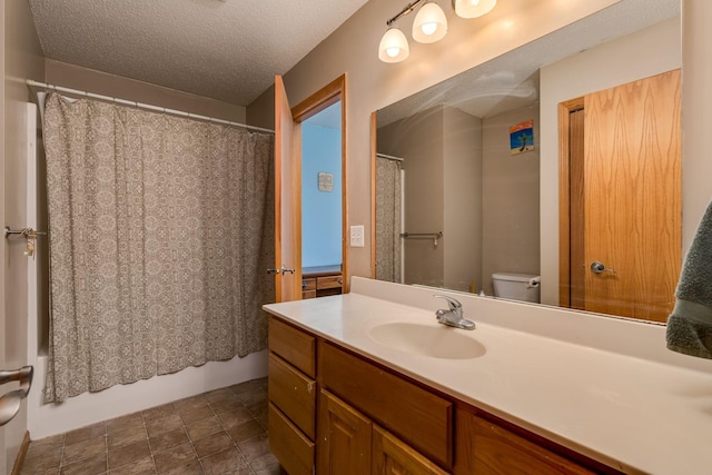full bath featuring toilet, a textured ceiling, vanity, and shower / bath combo with shower curtain
