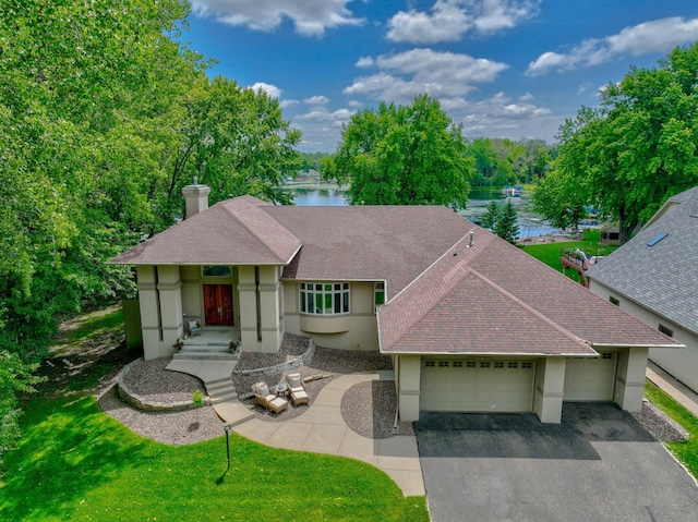 926 Kohlman Ln, Maplewood, MN 55109 - view of front facade featuring an attached garage, a shingled roof, asphalt driveway, a water view, and stucco siding