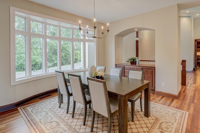 926 Kohlman Ln, Maplewood, MN 55109 - dining space featuring arched walkways, light wood finished floors, a chandelier, and recessed lighting