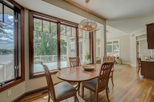 926 Kohlman Ln, Maplewood, MN 55109 - dining room featuring light wood-style floors, ceiling fan, and a chandelier