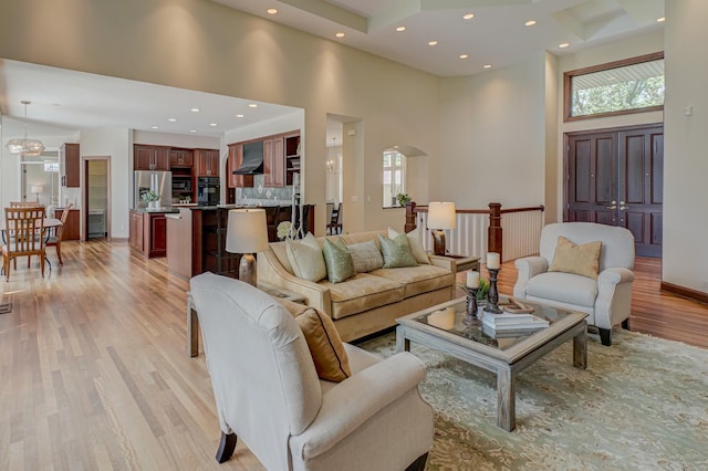 926 Kohlman Ln, Maplewood, MN 55109 - living area featuring a high ceiling, light wood-style flooring, plenty of natural light, arched walkways, and recessed lighting