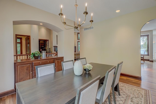 926 Kohlman Ln, Maplewood, MN 55109 - dining space with arched walkways, a chandelier, light wood-type flooring, and recessed lighting