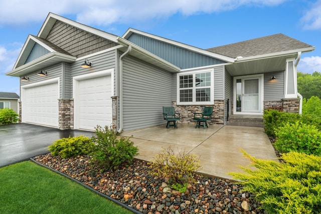9769 Jeremiah Ct NE, Hanover, MN 55341 - view of front of property with an attached garage, stone siding, driveway, and board and batten siding