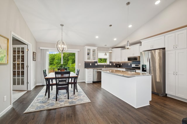9769 Jeremiah Ct NE, Hanover, MN 55341 - kitchen featuring appliances with stainless steel finishes, vaulted ceiling, a center island, white cabinetry, and tasteful backsplash