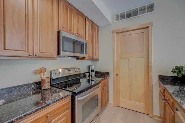 350 Main St N Unit 230, Stillwater, MN 55082 - kitchen featuring stainless steel appliances, light wood finished floors, and dark stone counters
