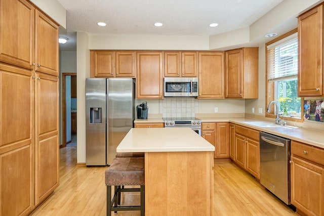 17299 66th Pl N, Maple Grove, MN 55311 - kitchen featuring stainless steel appliances, light wood-type flooring, a breakfast bar, decorative backsplash, and a center island
