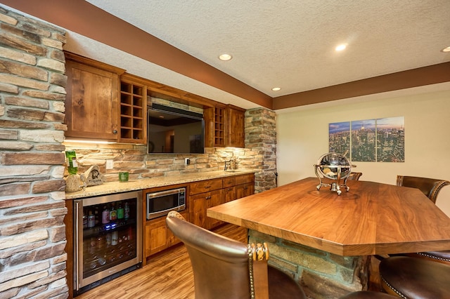 17299 66th Pl N, Maple Grove, MN 55311 - dining space featuring wine cooler, a bar, a textured ceiling, light wood-style floors, and recessed lighting