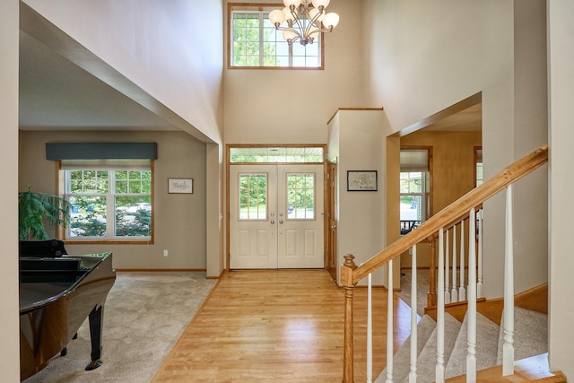 17299 66th Pl N, Maple Grove, MN 55311 - foyer entrance with healthy amount of natural light, a chandelier, stairway, a towering ceiling, and wood finished floors
