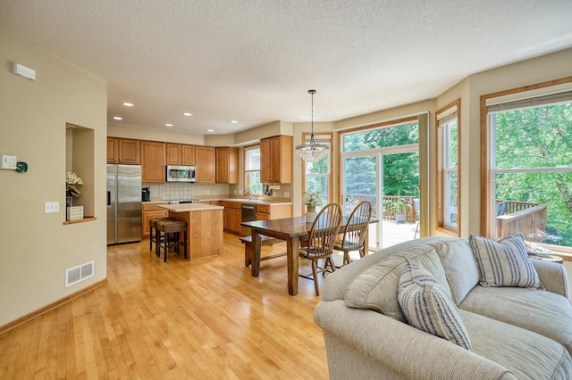 17299 66th Pl N, Maple Grove, MN 55311 - living area with light wood-type flooring, a textured ceiling, recessed lighting, and a chandelier