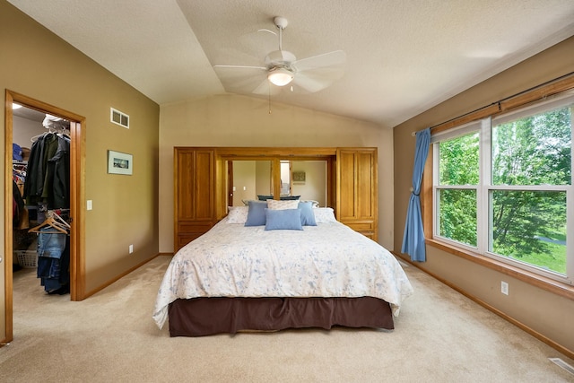 17299 66th Pl N, Maple Grove, MN 55311 - bedroom with a walk in closet, light carpet, vaulted ceiling, a closet, and a ceiling fan