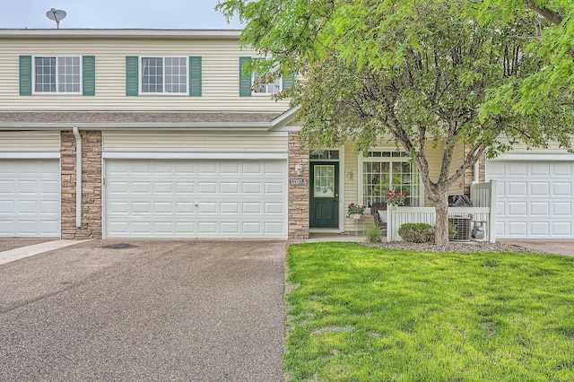 13397 Europa Ct N Unit 5, Hugo, MN 55038 - view of front of property with stone siding, a front lawn, driveway, an attached garage, and a shingled roof