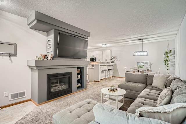13397 Europa Ct N Unit 5, Hugo, MN 55038 - living room with a textured ceiling, baseboards, a glass covered fireplace, and a chandelier