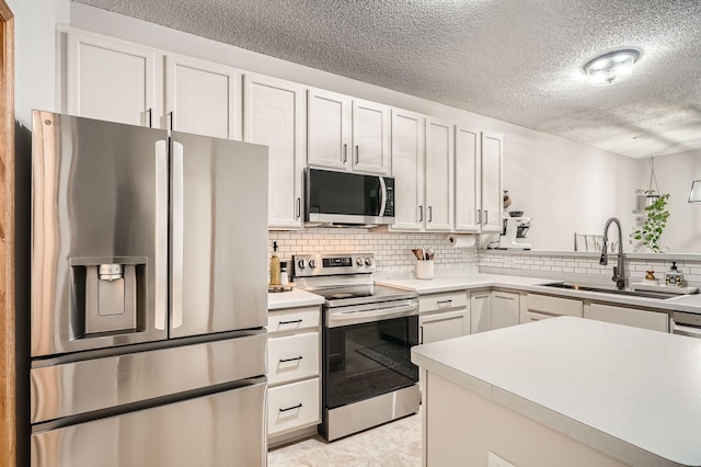 13397 Europa Ct N Unit 5, Hugo, MN 55038 - kitchen featuring stainless steel appliances, a sink, a textured ceiling, white cabinets, and backsplash
