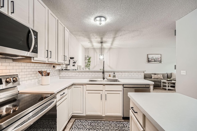 13397 Europa Ct N Unit 5, Hugo, MN 55038 - kitchen featuring appliances with stainless steel finishes, a sink, backsplash, light countertops, and a peninsula
