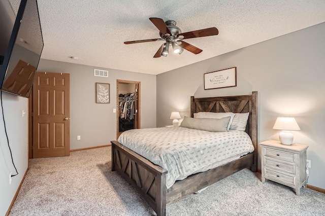 13397 Europa Ct N Unit 5, Hugo, MN 55038 - bedroom with light colored carpet, a walk in closet, a closet, a textured ceiling, and ceiling fan
