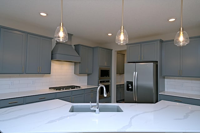 kitchen with gray cabinetry, premium range hood, a sink, and appliances with stainless steel finishes