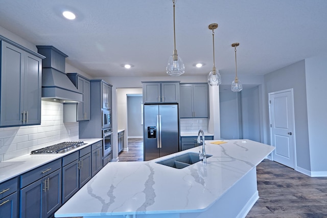 kitchen featuring recessed lighting, a sink, stainless steel appliances, premium range hood, and baseboards