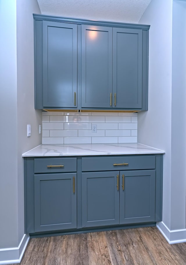 bar with tasteful backsplash, dark wood-style floors, and baseboards