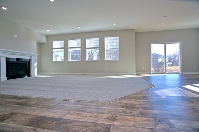 unfurnished living room featuring recessed lighting, plenty of natural light, and wood finished floors