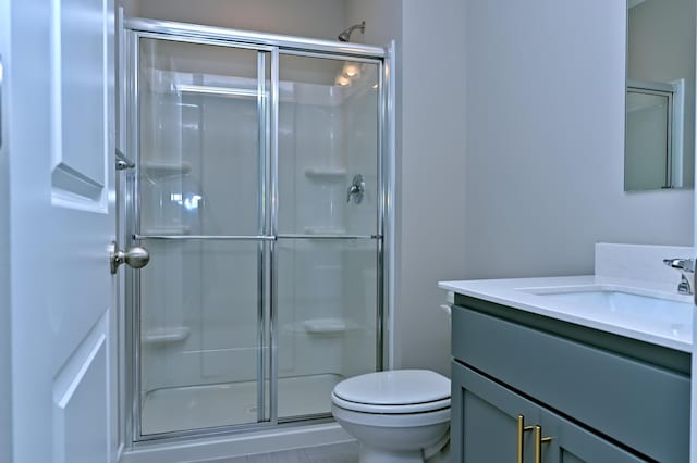 full bathroom featuring toilet, a shower stall, and vanity