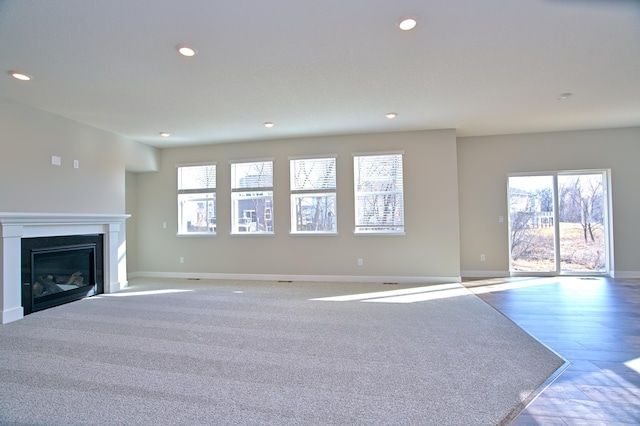unfurnished living room featuring baseboards, recessed lighting, and plenty of natural light