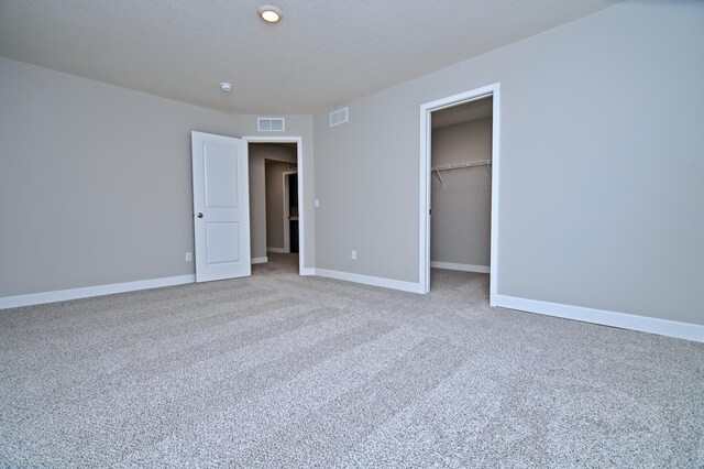 unfurnished bedroom featuring visible vents, baseboards, carpet flooring, and a closet