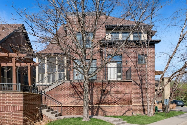 831 River Mews Ct, Minneapolis, MN 55414 - back of house featuring brick siding, roof with shingles, and stairs