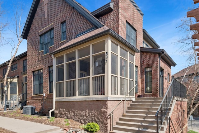 831 River Mews Ct, Minneapolis, MN 55414 - view of side of property with brick siding, a sunroom, and stairway