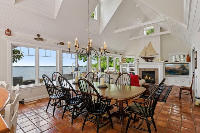 19820 Lakeview Ave, Deephaven, MN 55331 - dining room featuring high vaulted ceiling, a skylight, a brick fireplace, a water view, and a chandelier