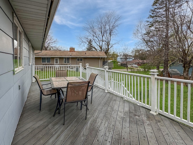 deck featuring a lawn and outdoor dining space