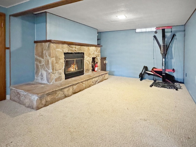 finished below grade area featuring a stone fireplace and carpet flooring