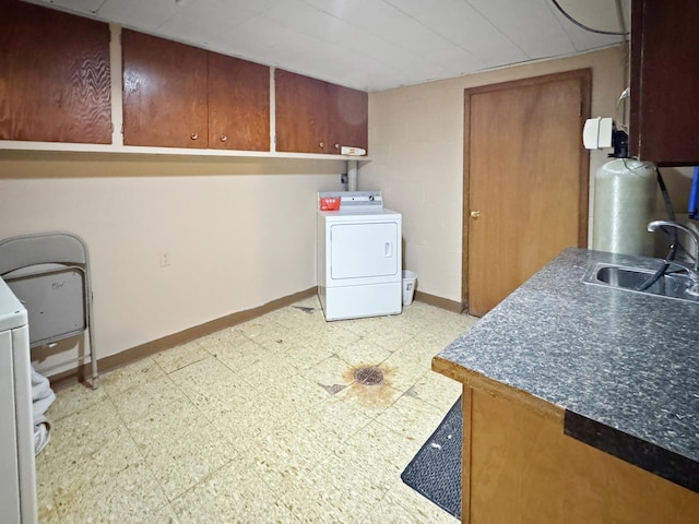 laundry area with light floors, a sink, washer / dryer, and baseboards
