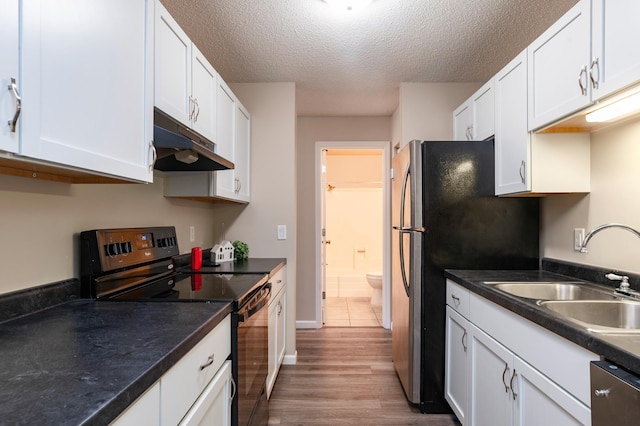 2930 Blaisdell Ave Unit 124, Minneapolis, MN 55408 - kitchen featuring appliances with stainless steel finishes, under cabinet range hood, a sink, white cabinets, and a textured ceiling