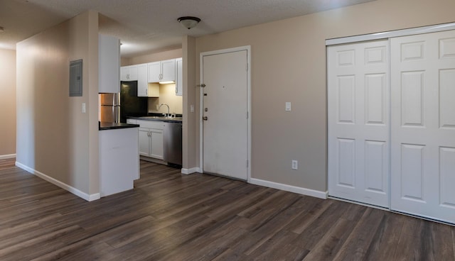 2930 Blaisdell Ave Unit 124, Minneapolis, MN 55408 - kitchen featuring electric panel, dark wood-style floors, dark countertops, and white cabinetry