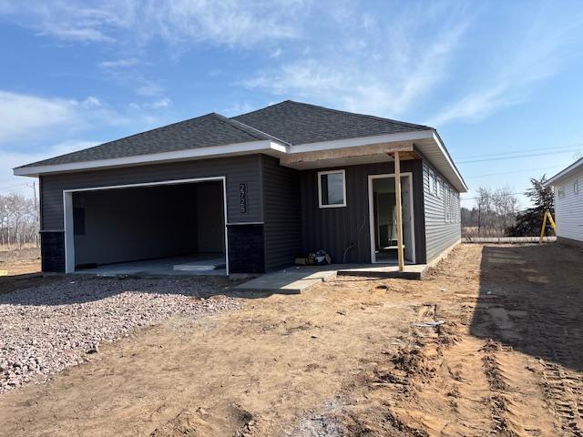 2728 229th Ln NW, Saint Francis, MN 55070 - rear view of house featuring an attached garage, board and batten siding, roof with shingles, and driveway