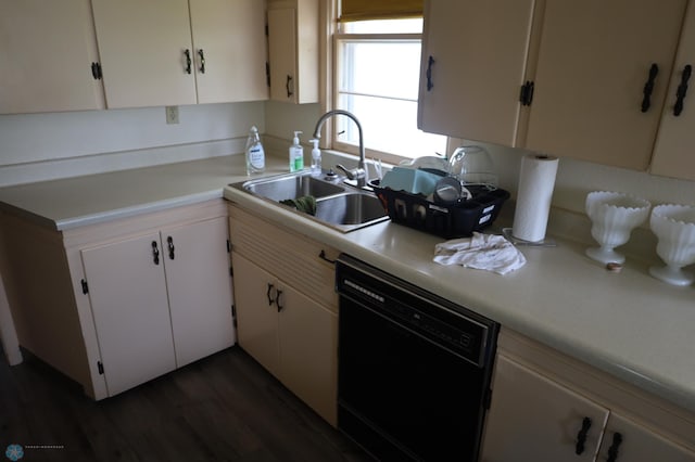 kitchen with light countertops, black dishwasher, white cabinets, dark wood-type flooring, and a sink