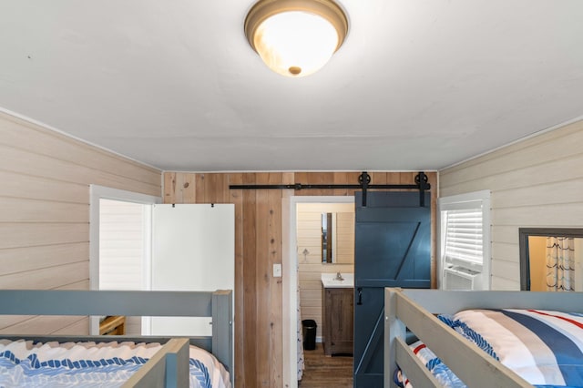 12742 Lake Miltona Dr NE, Miltona, MN 56354 - bedroom with wooden walls, a barn door, and wood finished floors